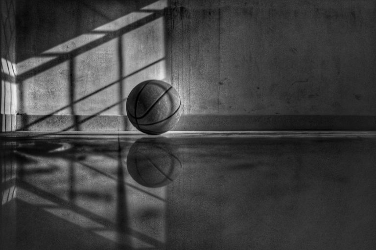 A basketball just leaving a shooter's hand mid-flight toward the basket.
