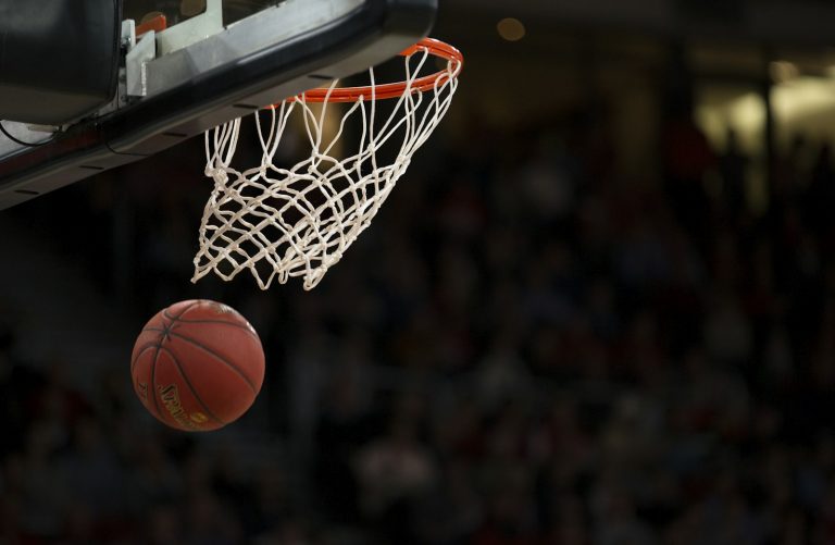 A basketball at center court of an arena during a playoff game.