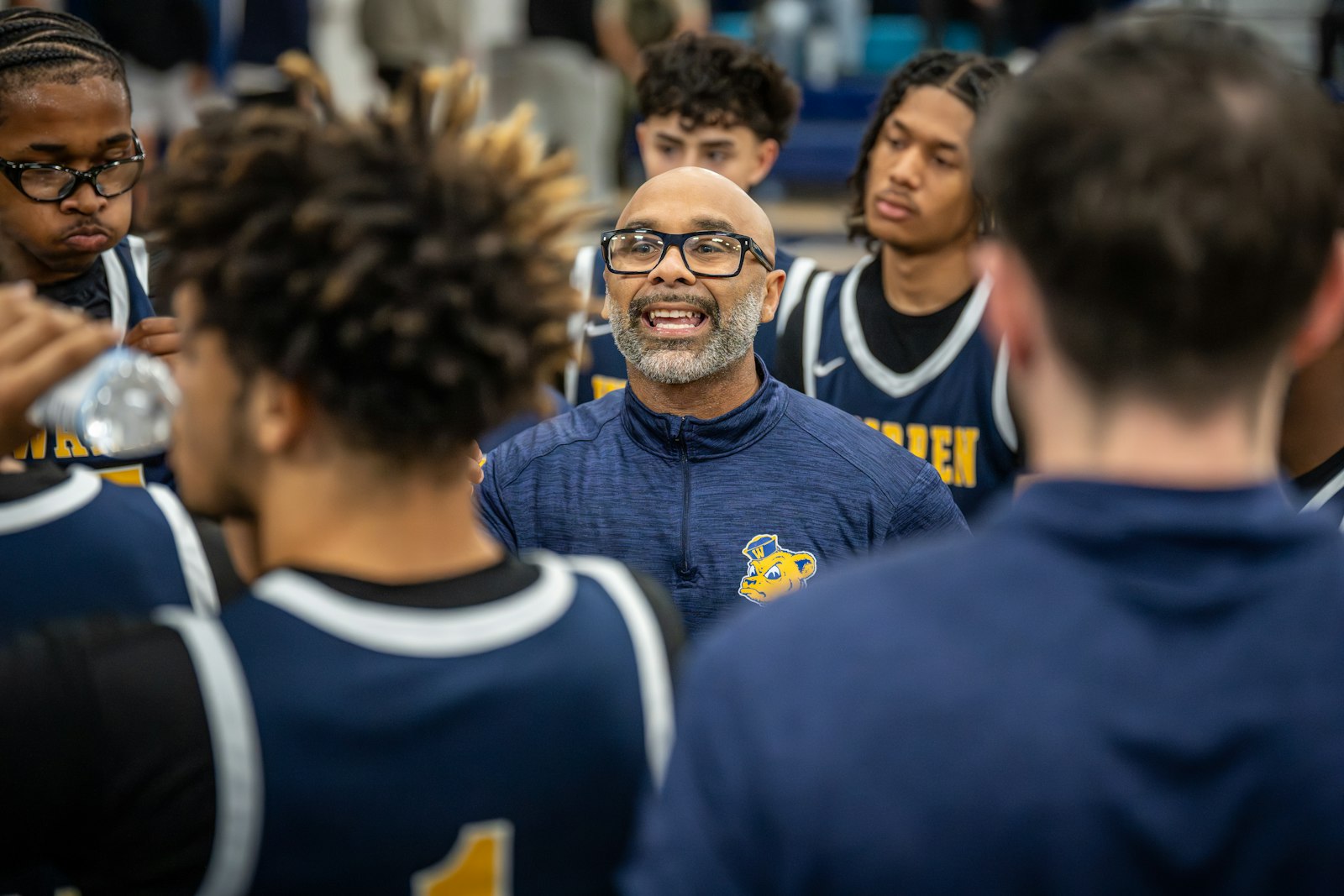 A basketball coach giving instructions to players during a huddle, used to illustrate how metrics inform strategic decisions.