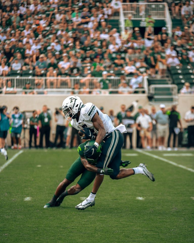 A football player running with the ball on the field, motion in frame.