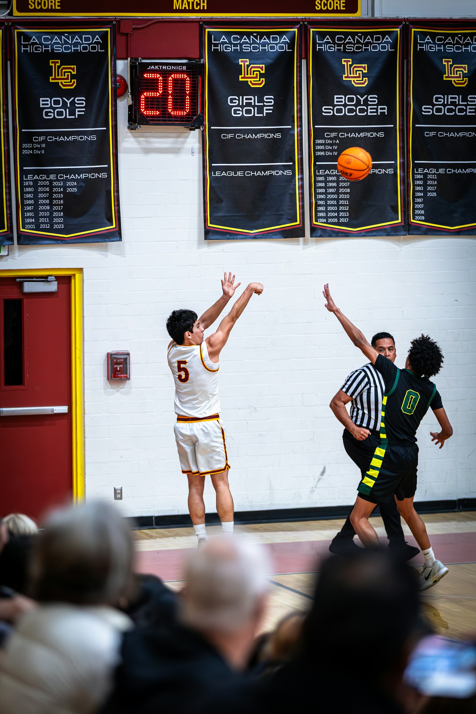 A basketball player shoots while a defender watches, used to illustrate how a player's statistical profile changes when his role and the defensive attention against him shift.