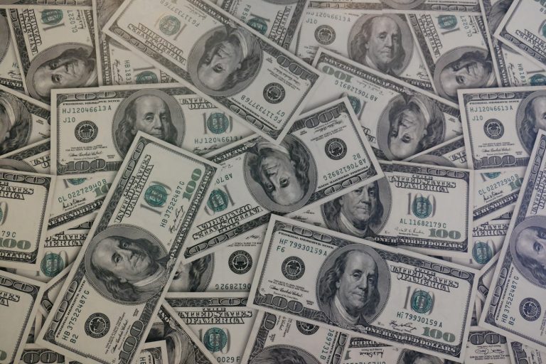 A lot of 100 US dollar banknotes stacked together, used to illustrate the betting and probability stakes behind Bayesian updating in sports analytics.