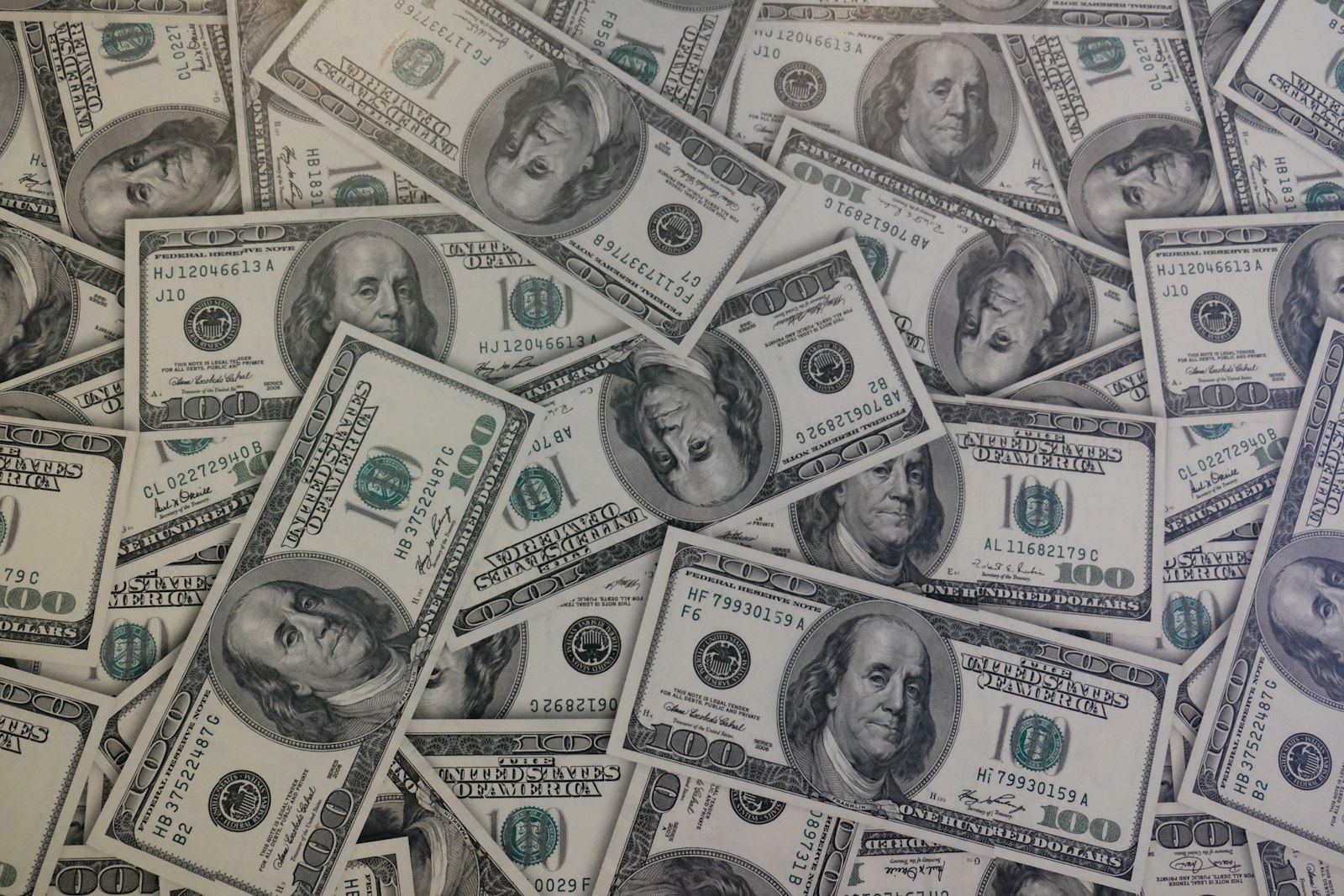 A lot of 100 US dollar banknotes stacked together, used to illustrate the betting and probability stakes behind Bayesian updating in sports analytics.