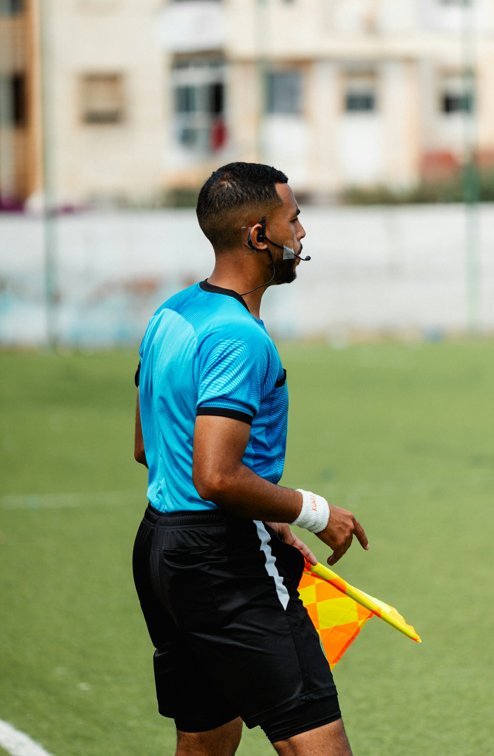 A soccer referee stands on the soccer field during a match.