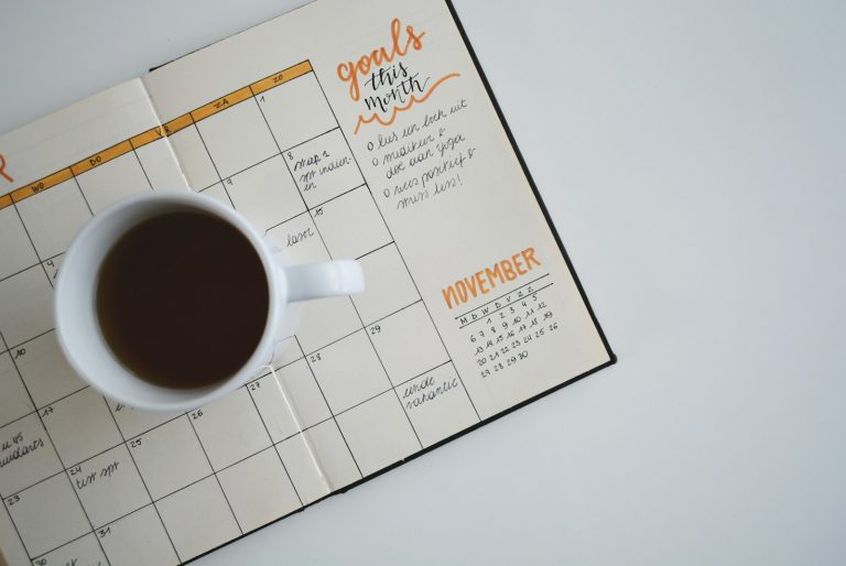 A planner and calendar on a desk for scheduling sports games.