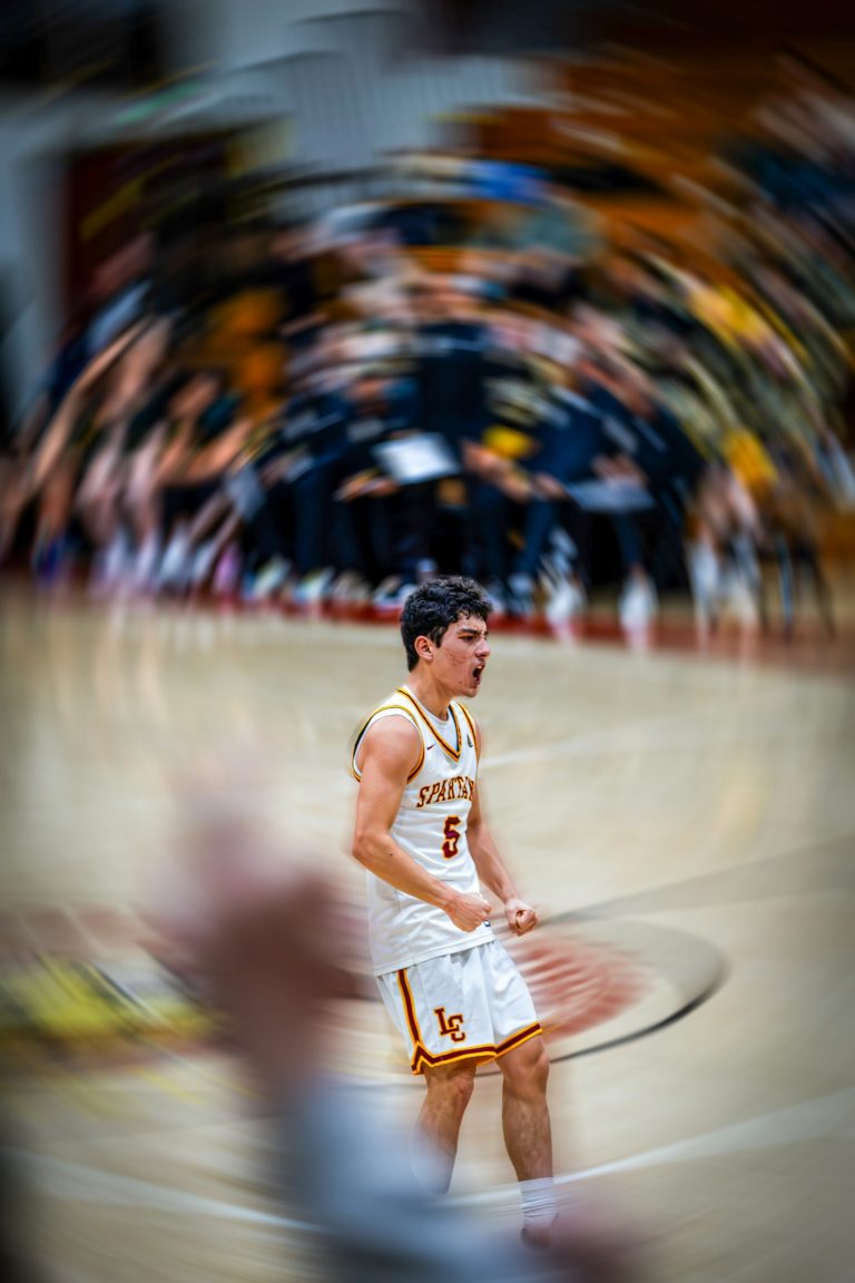 A basketball player screaming with emotion after a play during a competitive game.