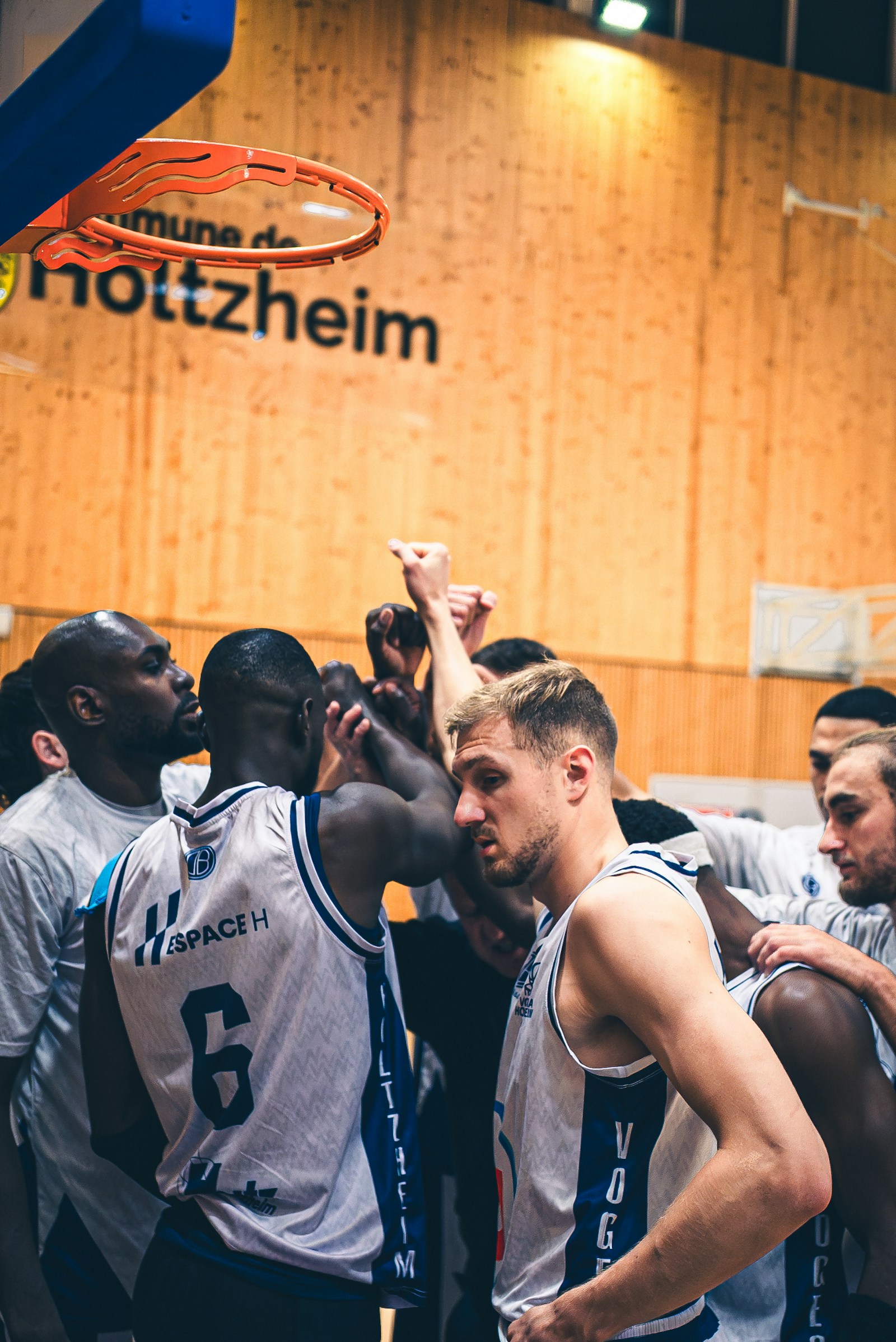 Basketball players huddle together during a game to discuss strategy.
