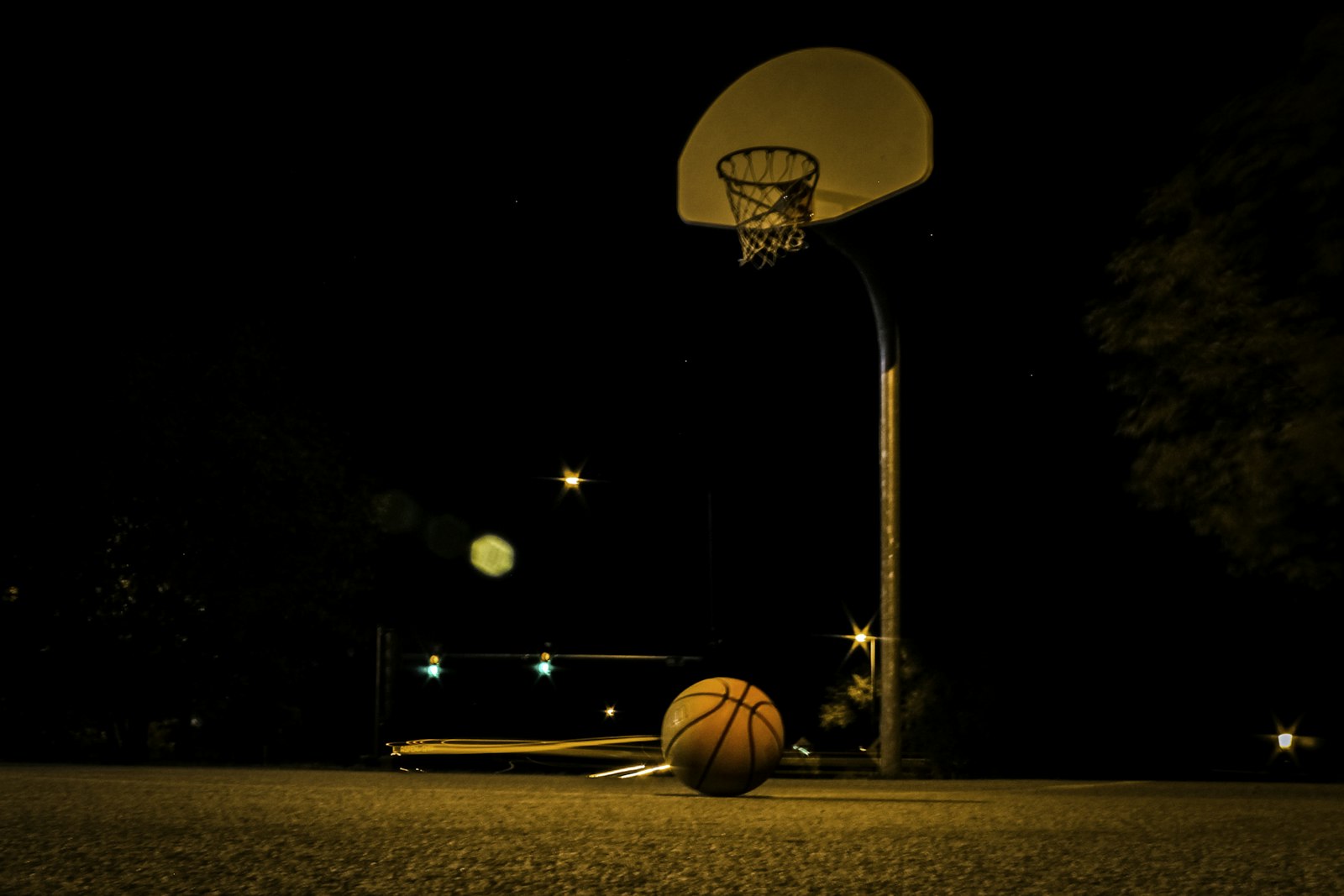 Basketball hoop illuminated by arena lights at night, used to illustrate the spotlight dynamics of NBA All-Star voting and modern player evaluation.