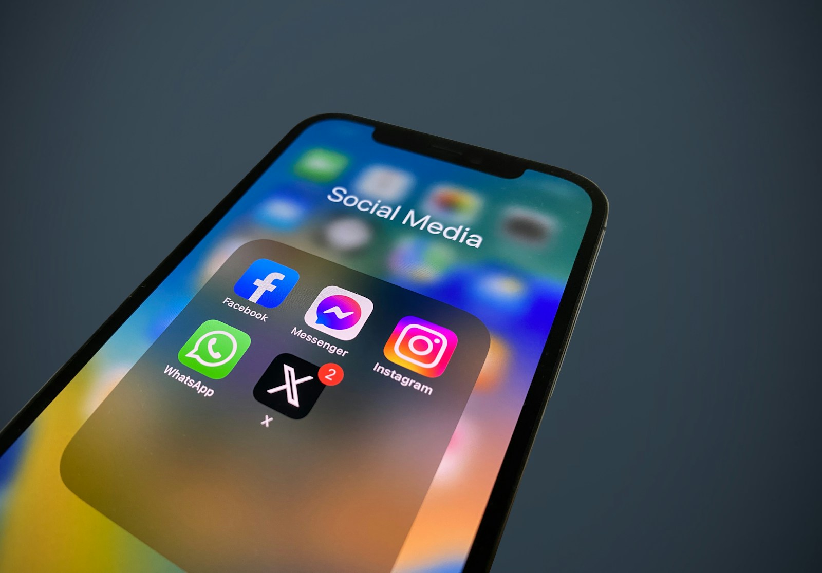 A close-up of a cell phone with social media icons displayed.