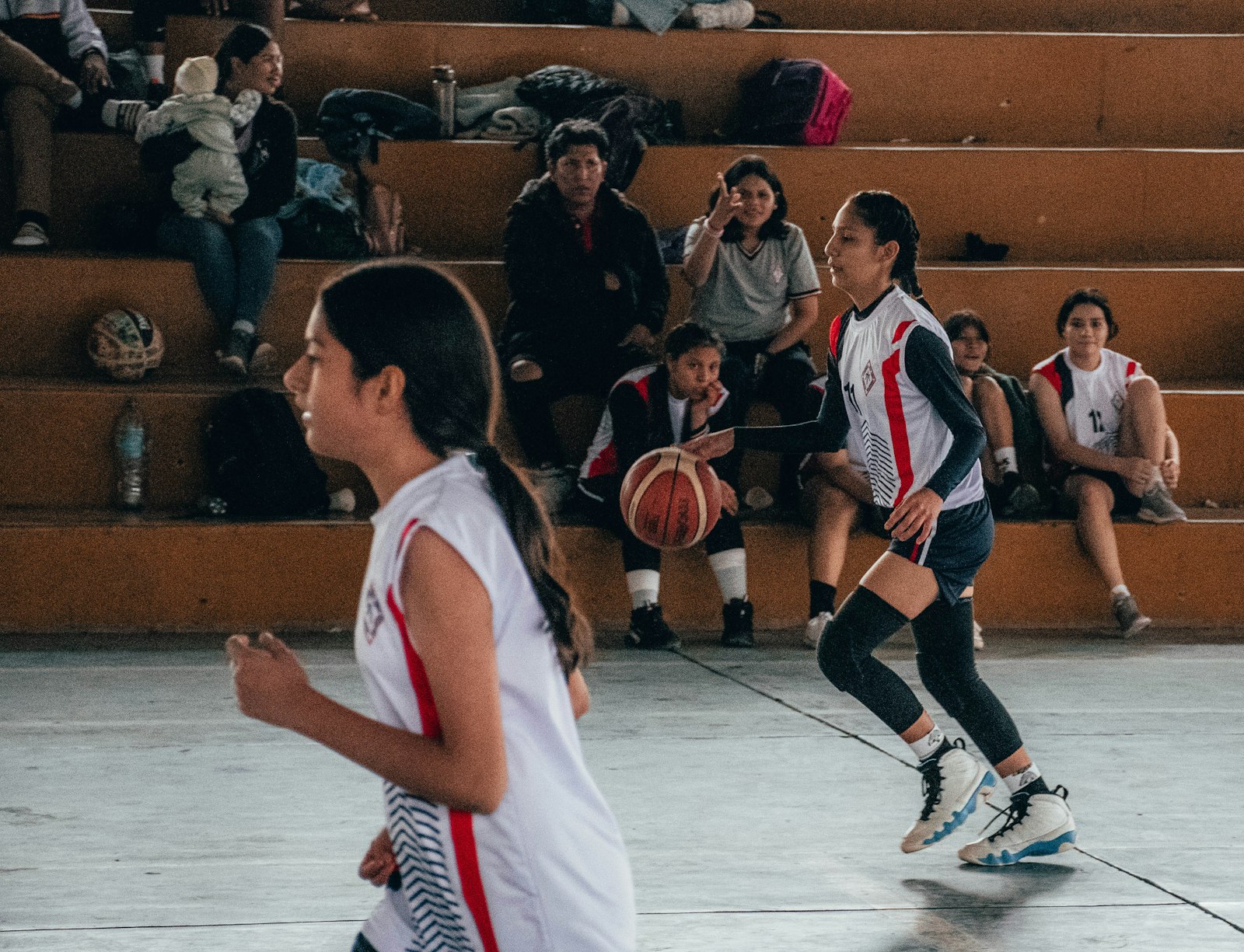 A group of young women playing basketball, used to illustrate the analytical lens for reading the Women NCAA Tournament.