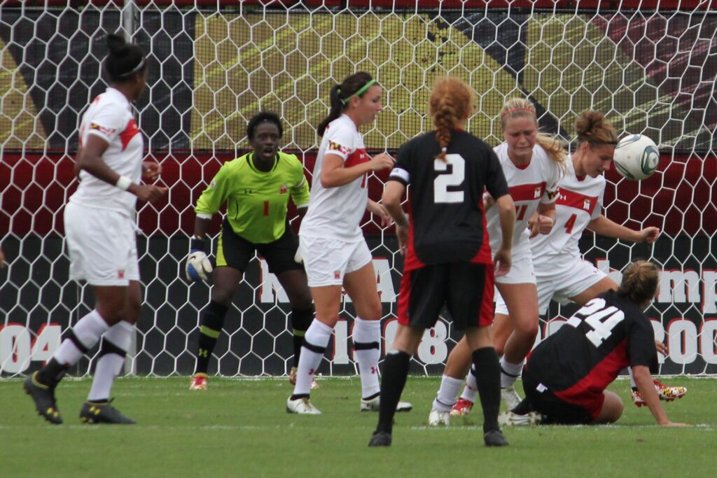 Two players rising together to meet a crossed ball close to the near post