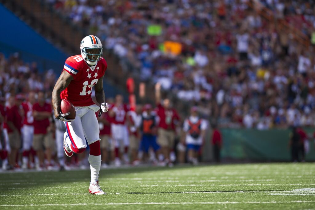 A receiver catching the ball while breaking inside with a defender trailing him