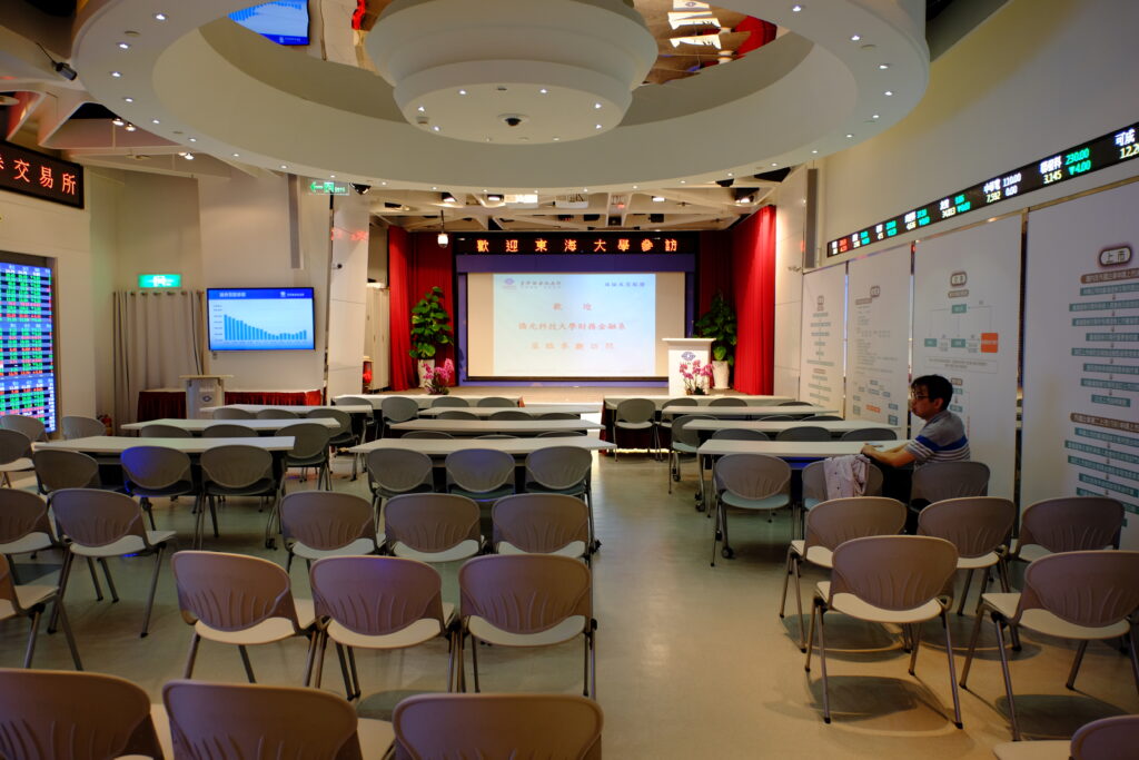Rows of empty chairs facing a podium in a stadium media room before a session