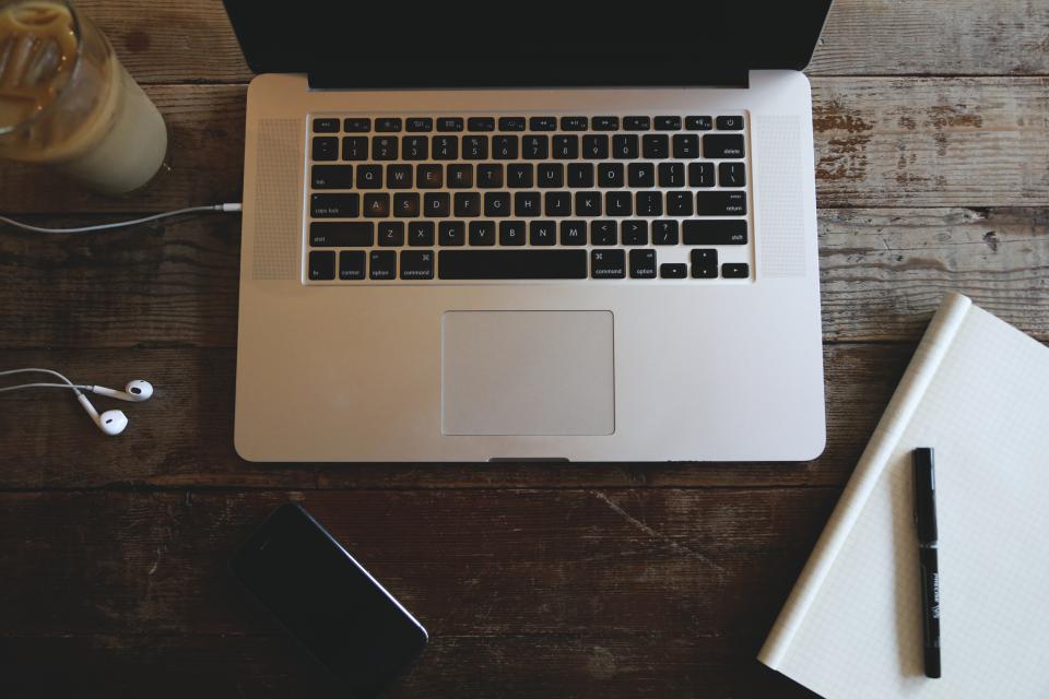 A laptop and a pair of headphones on a desk with an editing window open