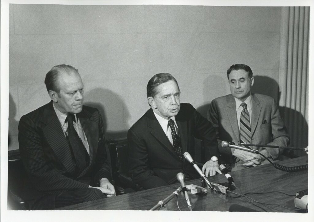 A row of recorders and microphones lined up in front of two empty chairs