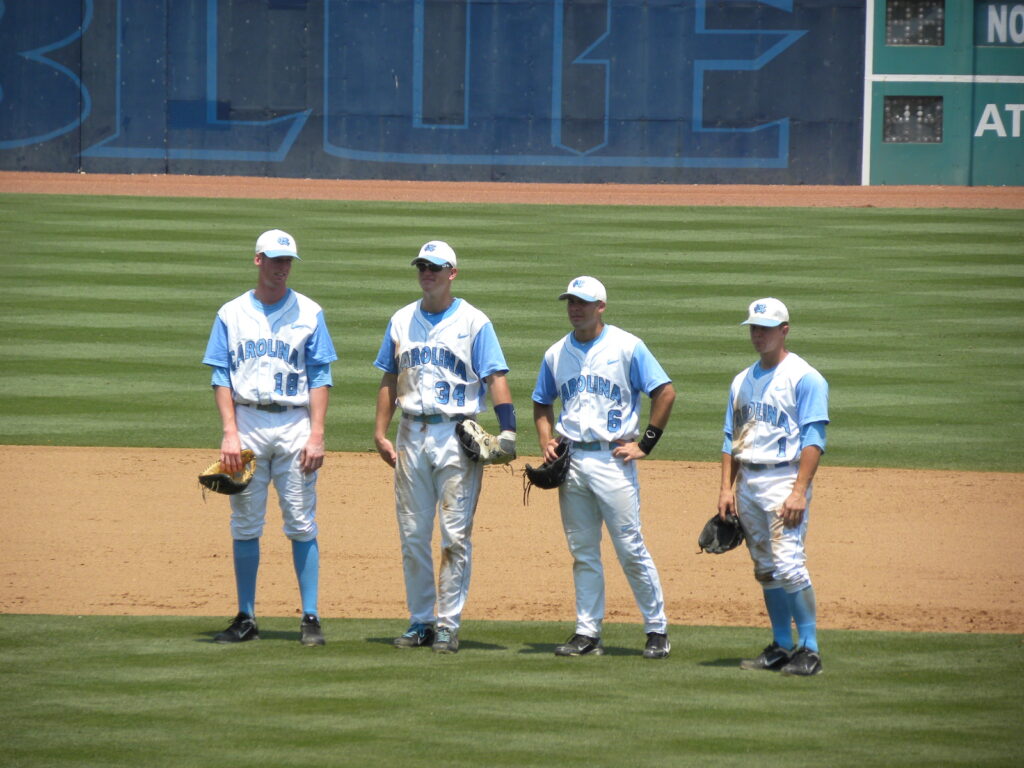 An infielder positioned in the outfield grass receiving and redirecting a relay throw