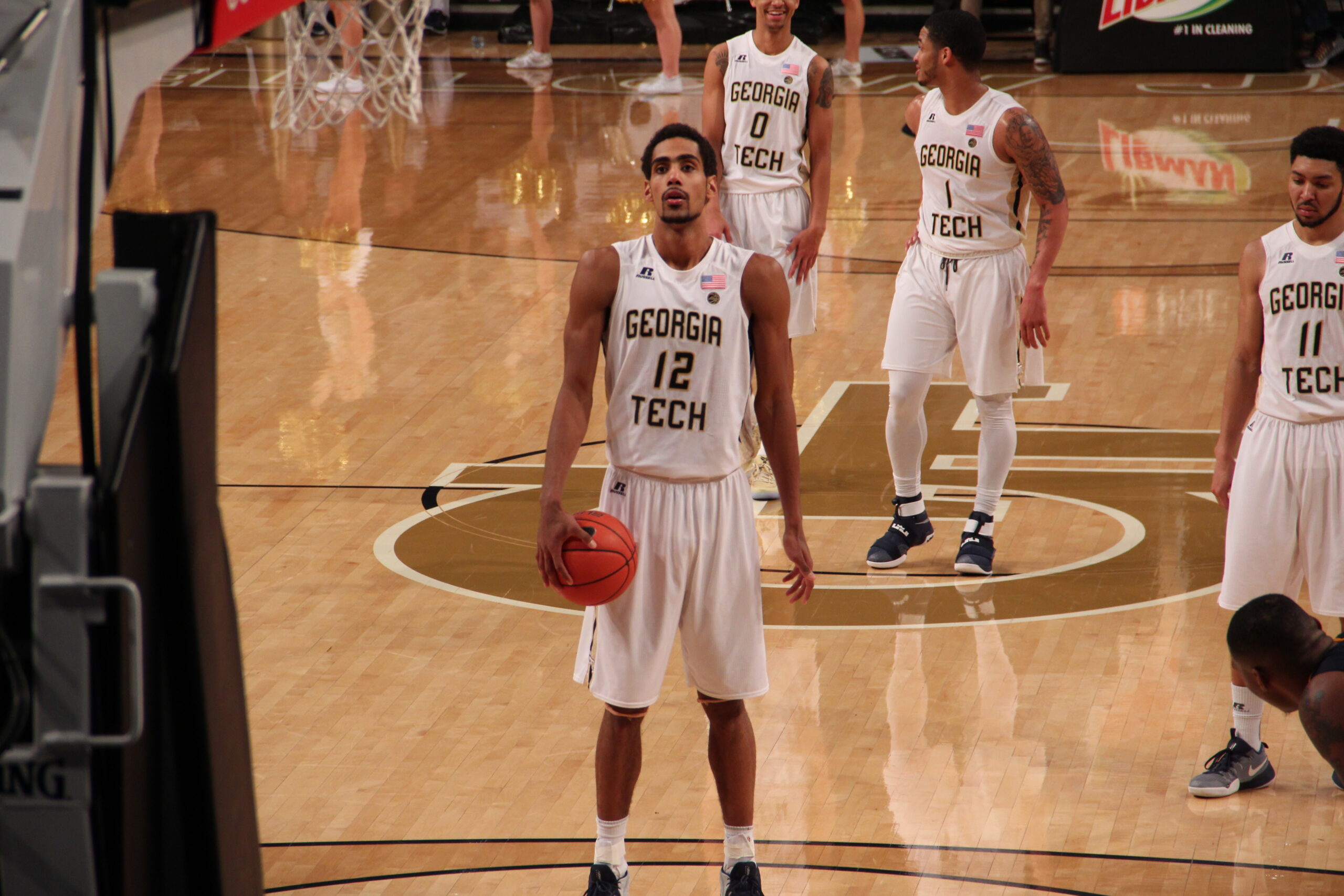 A player at the line preparing to shoot with opponents boxed out along the lane