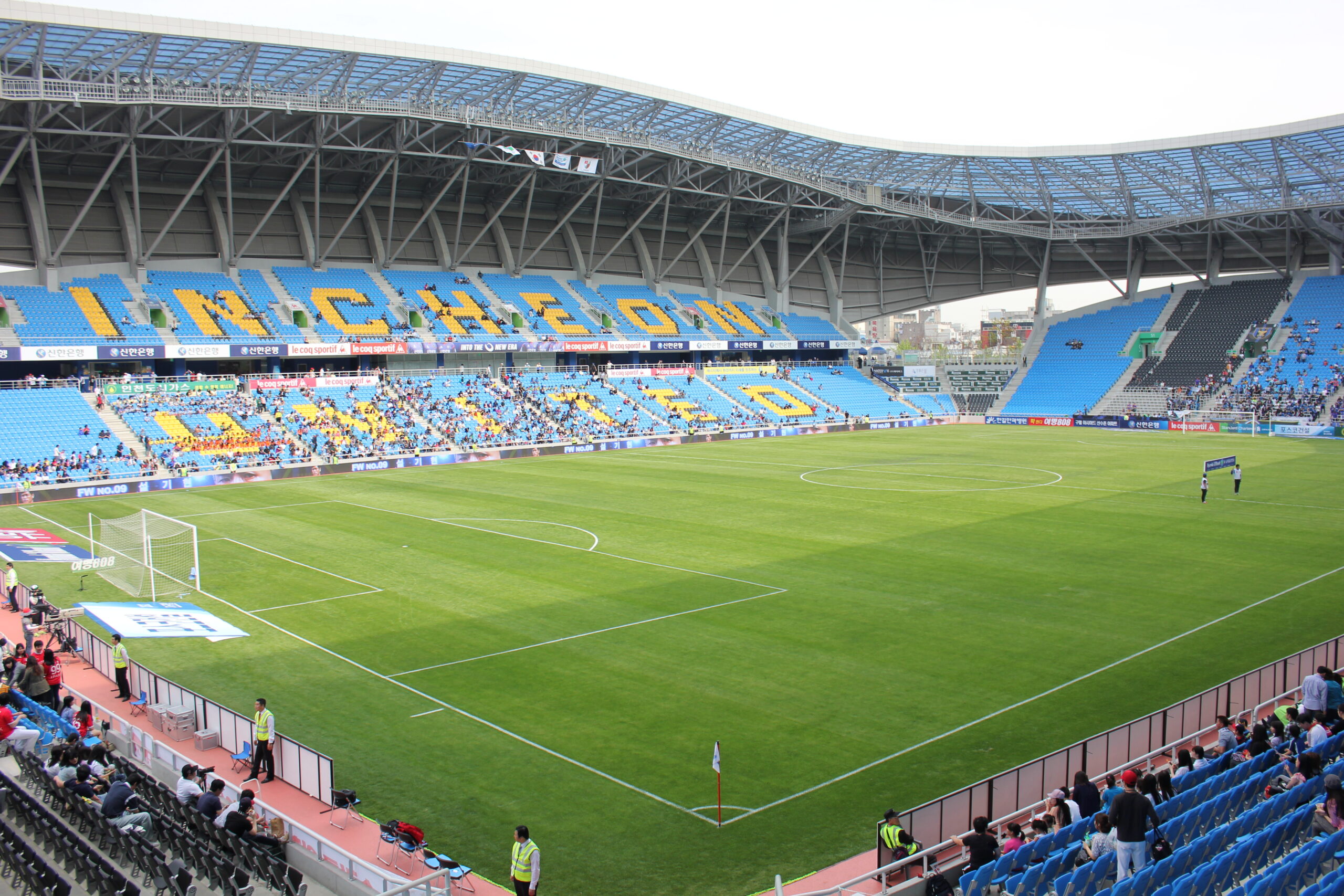 A stadium scoreboard displaying match statistics above the pitch during a football game