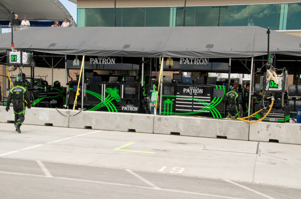 A pit crew changing tires on a race car during a pit stop