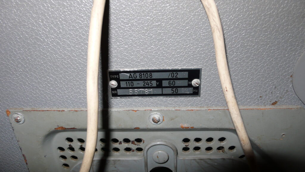 An open reel tape machine with spools mounted, its controls and meters visible on the front panel